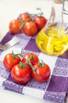 few fresh ripe tomatoes on a branch with olive oil