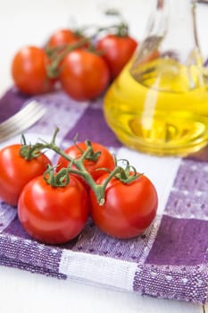 few fresh ripe tomatoes on a branch with olive oil