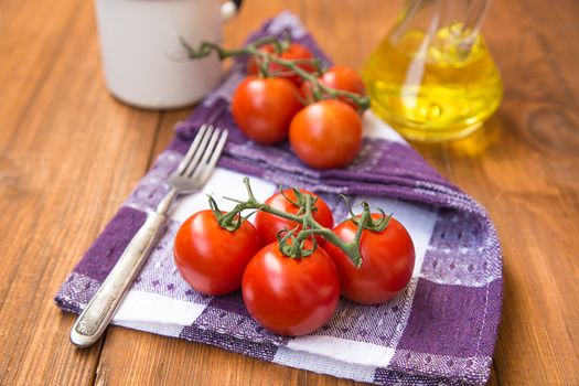 few fresh ripe tomatoes on a branch with olive oil