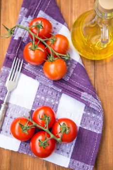 few fresh ripe tomatoes on a branch with olive oil