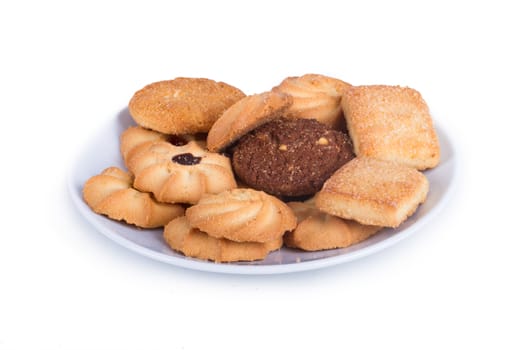 Delicious biscuit cookies on plate, isolated on white background.