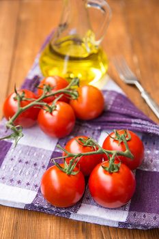 few fresh ripe tomatoes on a branch with olive oil