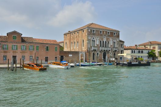 Exterior glass factory in Murano next to an historical palace, in the Venetian Lagoon, northern Italy.