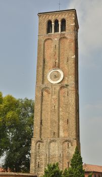 Bell brick tower with clock in the island of Murano, Venice, Italy.