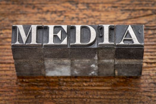 media word in mixed vintage metal type printing blocks over grunge wood