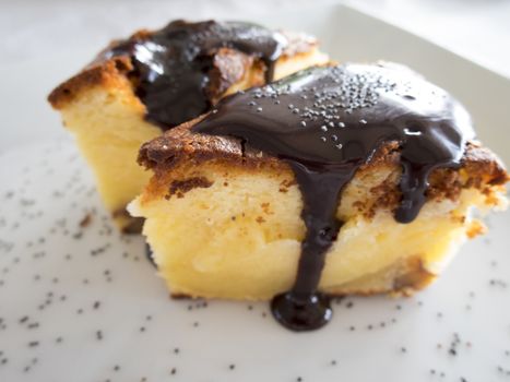 two pieces of cream cake with chocolate sauce on white dish