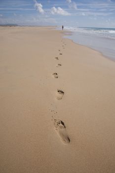 back far old woman with swimsuit walking beach next to Conil Cadiz Andalusia Spain