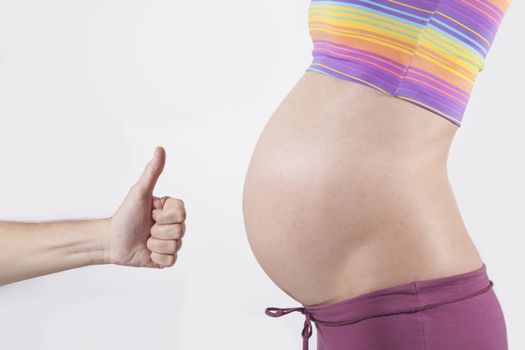hand okay to tummy of naked pregnant woman