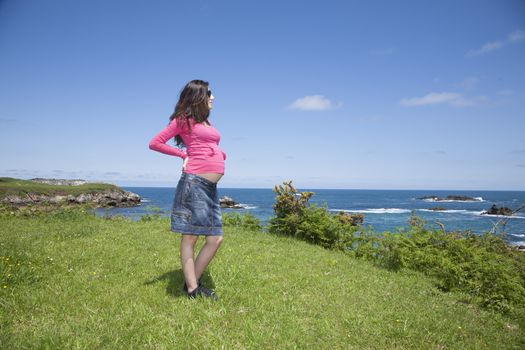 pregnant woman with pink jersey at Asturian coast
