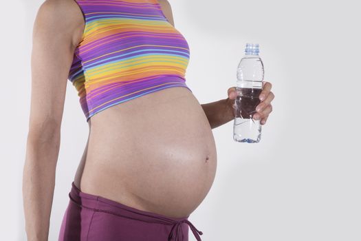 paunch pregnant woman with plastic water bottle