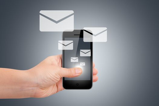 Communication concept with email icons, young female hand holding smart phone on dark background.