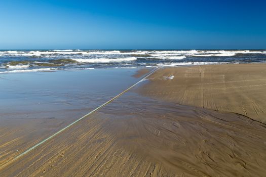 Wire going into sea and sand texture