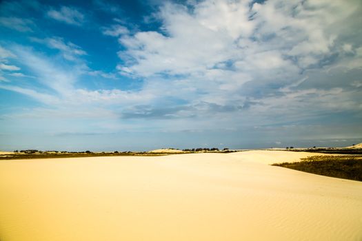 Cloud sky and sand dune horizon