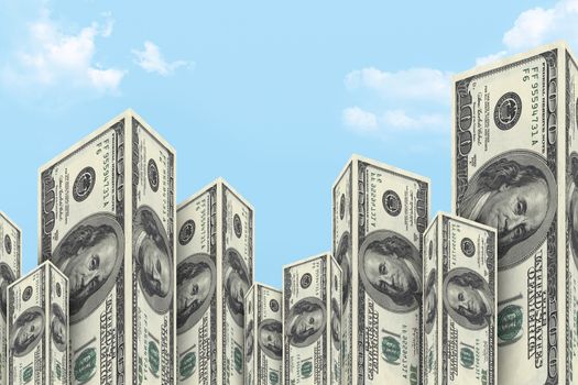 Skyscraper buildings made from one hundred dollar money banknotes on cloudy background.