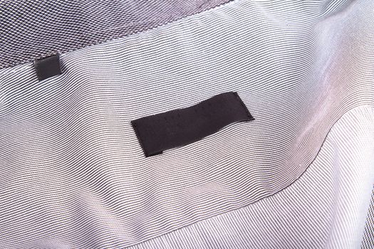 Close up view of blank black label in shirt.