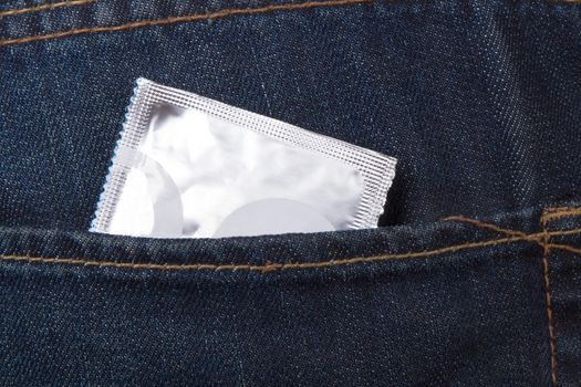 Condom packet in jeans pocket for safe sex.