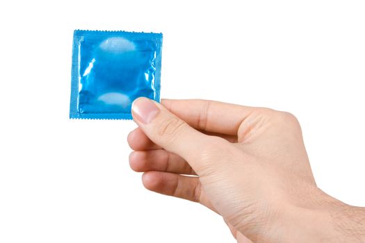 Hand holding blue packet condom, isolated on white background.