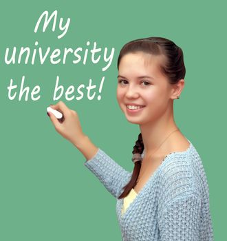 Girl student writes chalk "My university the best!". Isolated on a green background.