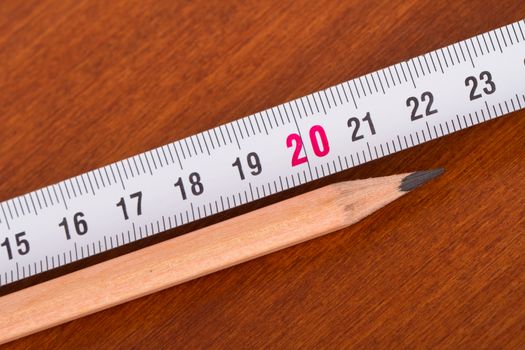 Top view of wood pencil and steel ruler for engineering drawing on wooden table.