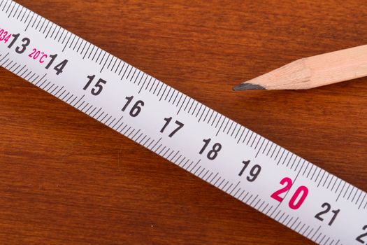 Top view of wood pencil and steel ruler for engineering drawing on wooden table.