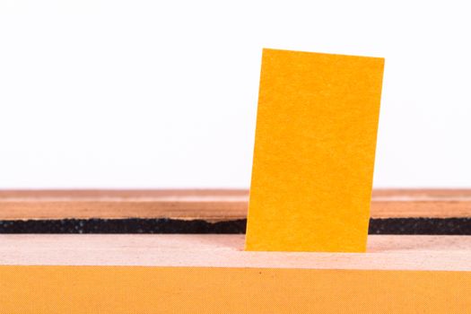 Yellow post it marker inside book, front view, isolated on white background.