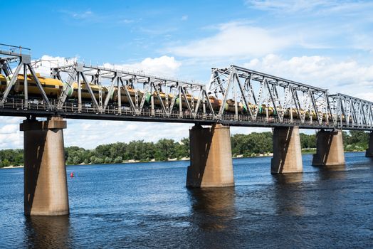 Petrivskiy railroad bridge in Kyiv across the Dnieper with freight train on it.