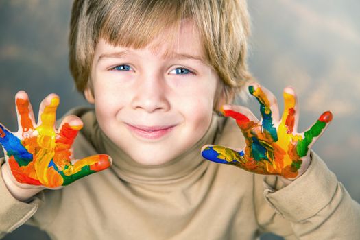 little boy hands painted  in colorful paints