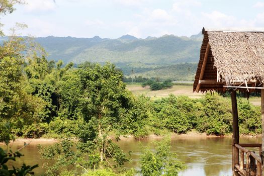 Hut near river and mountain in Thailand