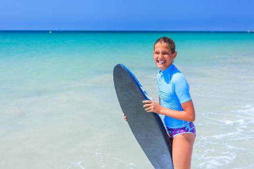 Teenage girl in blue has fun surfing