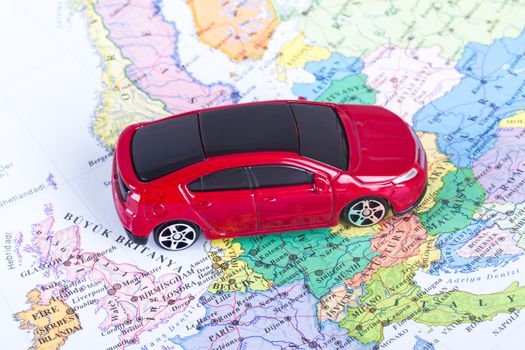 Top view of red, toy, small car on colorful map.