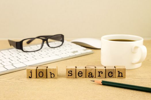 Job search word on rubber stamps place on table with a cup of coffee, keyboard and glassess, concept for employment