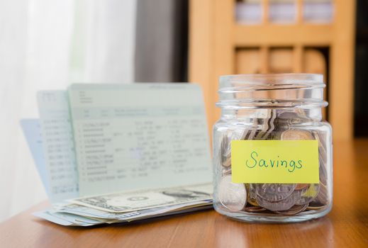 Many world coins in money jar with savings label on jar, concept to financial planning