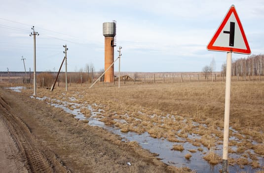 Russia, the Urals, landscape with water tower and a road sign
