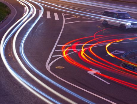 evening crossroad with varicolored lines of lights of cars. abstraction