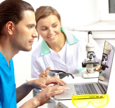 researchers in the lab looking at the computer screen and smile