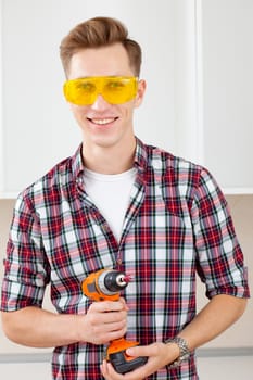 smiling repairman in eyeglasses and with a drill in his hands