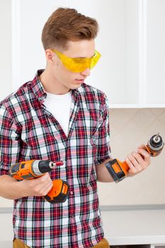 smiling repairman in yellow safety glasses selects tool