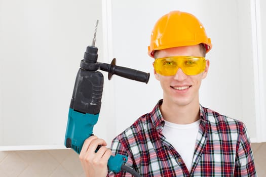 smiling worker in protective eyeglasses and orange helmet with rock-drill