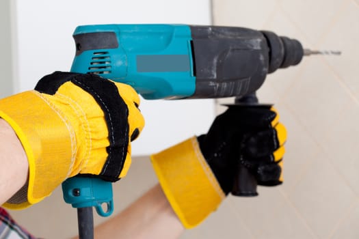 worker hands in protective gloves with perforator