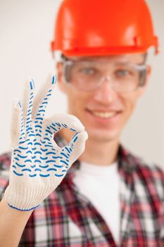 repairman making a perfect gesture with his gloved hand with focus to his hand