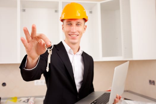 smiling engineer gives keys of new apartment