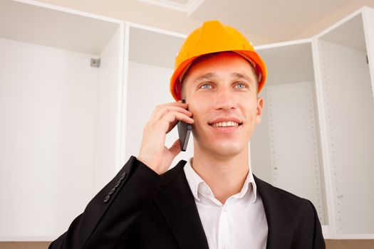 engineer talking on the phone in the interior of a new apartment