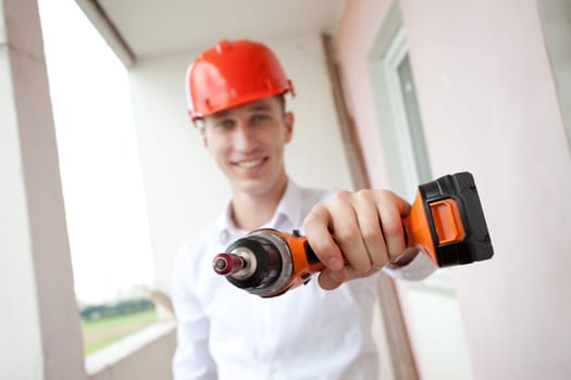 smiling worker with drill in hand outstretched