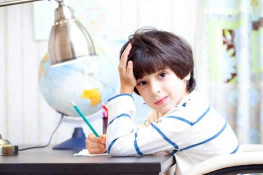 schoolboy doing homework at his desk