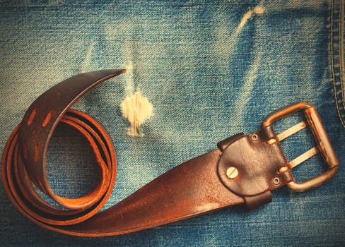 a rolled-up vintage belt on old blue jeans, instagram image style