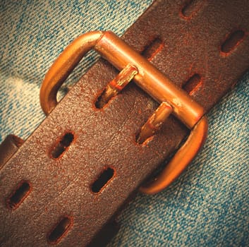 clasped aged leather belt on jeans background. instagram image style