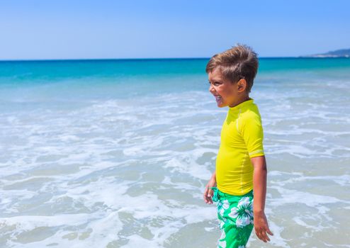 Little cute boy relaxing at the beach near ocean