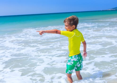 Little cute boy relaxing at the beach near ocean