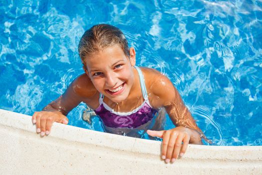 Cute happy young girl swimming and snorking in the swimming pool