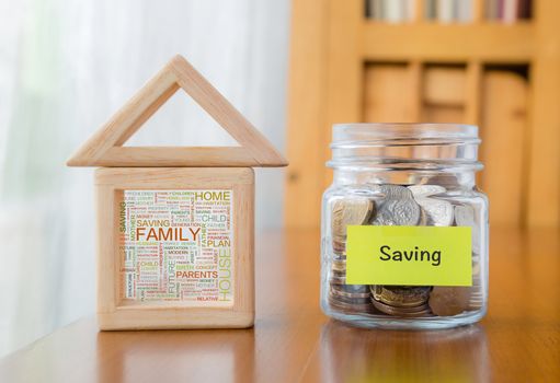 Saving label on money jar and wooden home  blocks with house and family word cloud